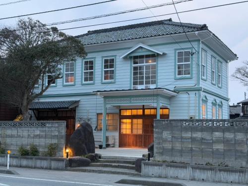 a blue house with a large door at 古民家ラグジュアリーホテル 金井西洋館 in Sado