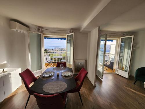 une salle à manger avec une table et des chaises et un balcon dans l'établissement Élégance et mer à Juan-les-Pins, à Antibes