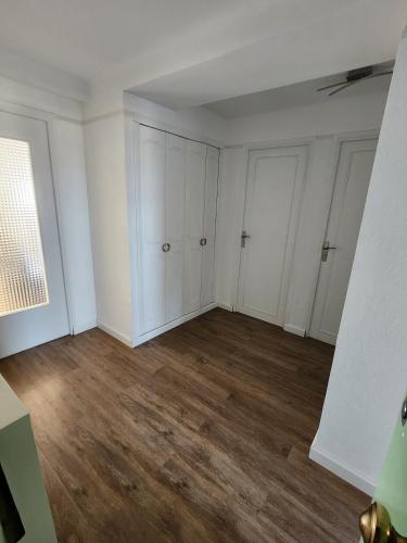 Cette chambre vide est dotée de murs blancs et de parquet. dans l'établissement Élégance et mer à Juan-les-Pins, à Antibes