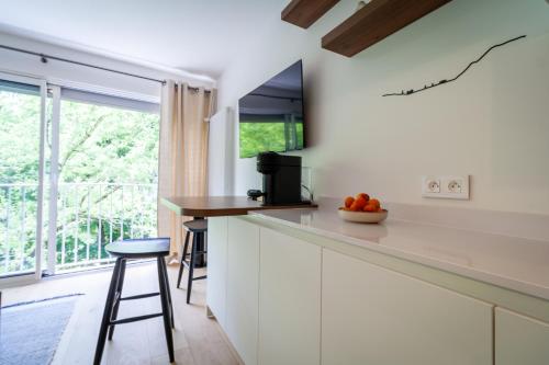 une cuisine avec des placards blancs, un comptoir et une fenêtre dans l'établissement Lac & Nest, à Annecy