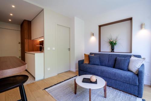 un salon avec un canapé bleu et une table dans l'établissement Lac & Nest, à Annecy