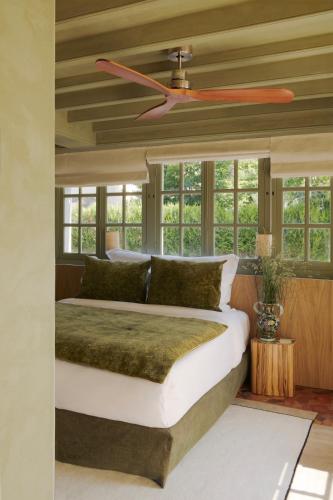 une chambre avec un lit et un ventilateur de plafond dans l'établissement La Folie Barbizon, à Barbizon