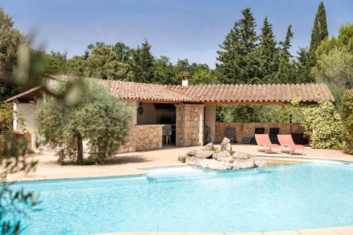 une piscine avec deux chaises et une maison dans l'établissement Maison VALFLO, à Saint-Cézaire-sur-Siagne