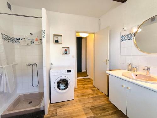 une salle de bain avec une machine à laver et un lavabo dans l'établissement Zigzag house sleeps 4, à Andernos-les-Bains