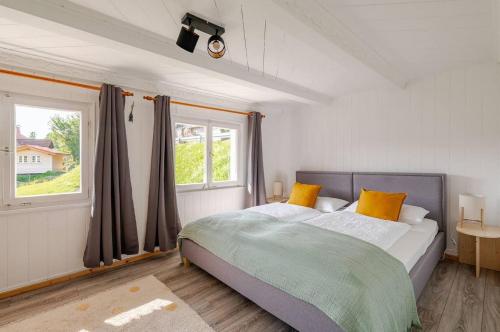 a bedroom with a bed with yellow pillows and a window at Gemütliches Schwarzwaldhaus im Ferienparadies Todtnau in Todtnau