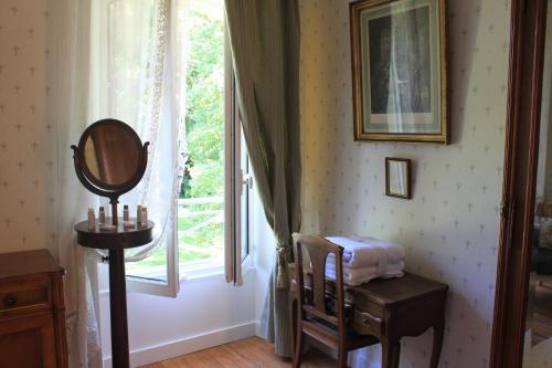 a dressing room with a mirror and a window at Château de Miguillaume 