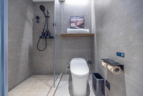 a small bathroom with a toilet and a shower at Atour Hotel Beijing Sanlitun North Gongti Road in Beijing