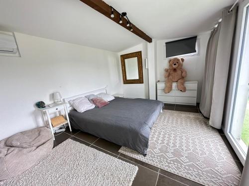 - une chambre dotée d'un lit avec un ours en peluche assis sur une fenêtre dans l'établissement Quiet in nature - Nice, à Nice