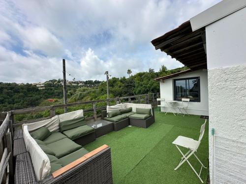 un patio avec de l'herbe verte et des canapés sur un balcon dans l'établissement Quiet in nature - Nice, à Nice
