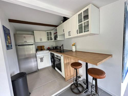 une cuisine avec des armoires blanches et un comptoir en bois dans l'établissement Quiet in nature - Nice, à Nice