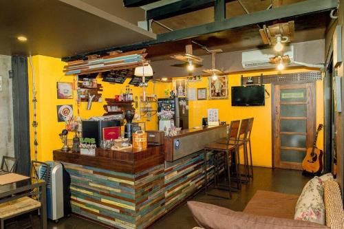 a bar in a restaurant with yellow walls at Norn-Nanta House in Chiang Mai