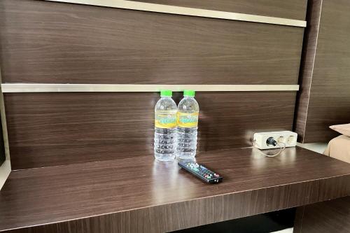 two bottles of water and a remote control on a table at Hotel Ramayana Garut in Garut