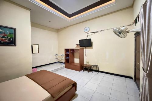 a hotel room with a bed and a tv at Hotel Ramayana Garut in Garut