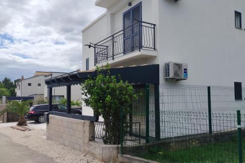 a white house with a gate and a fence at Apartments and rooms with parking space Starigrad, Paklenica - 24535 in Starigrad-Paklenica