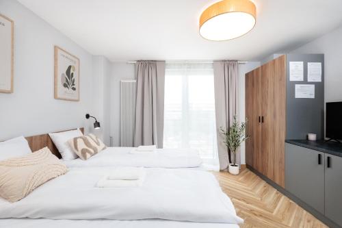 two white beds in a bedroom with a television at Nowy Hotel Monika - by Upstairs in Kraków