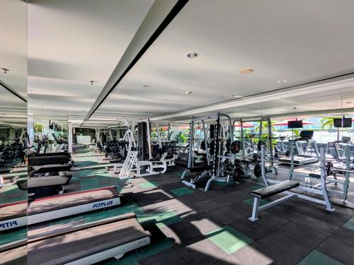 a gym with several treadmills and machines at Grand Zuri Cikarang Jababeka in Cikarang