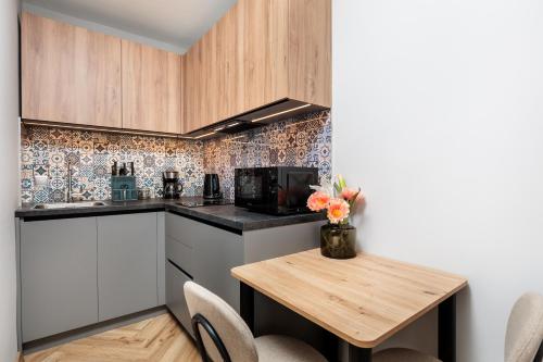 a small kitchen with a table and a microwave at Nowy Hotel Monika - by Upstairs in Kraków