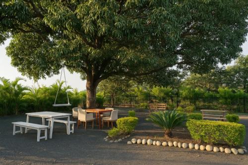a table and chairs under a tree in a park at Tiger Safari Lodge in Dodi