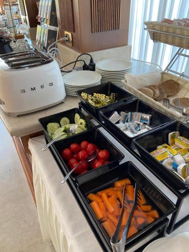 a buffet with several trays of vegetables on a counter at Hotel Olivo in Arco