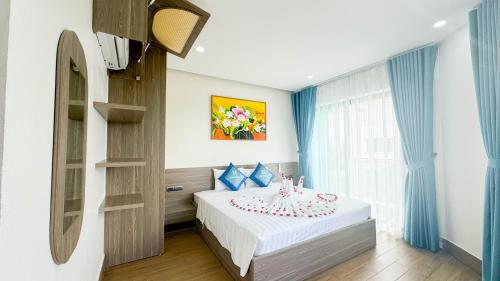 a bedroom with a bed and a table with a cake on it at Xanh Melody Resort in Bắc Ninh