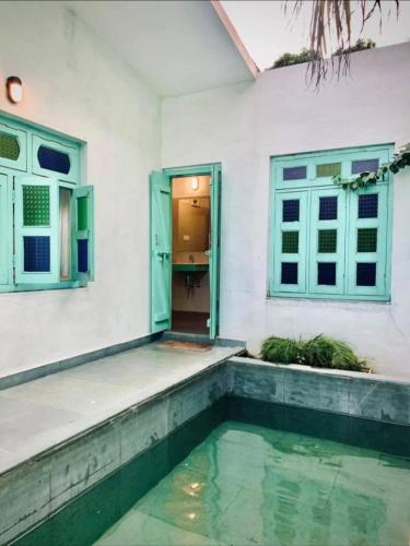 a house with a swimming pool in front of a house at Tiger Safari Lodge in Dodi