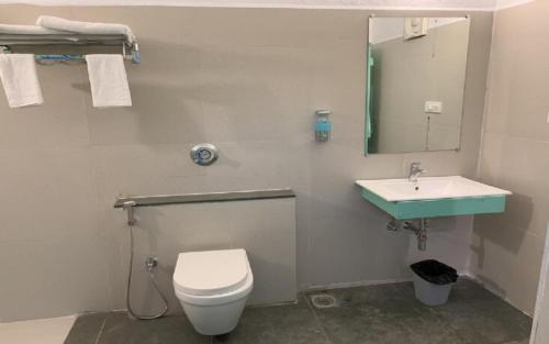 Un baño con un inodoro blanco y un lavabo. en Tiger Safari Lodge, en Dodi
