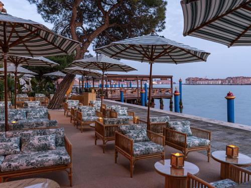 a row of chairs and umbrellas at a restaurant at Hotel Cipriani, A Belmond Hotel, Venice in Venice