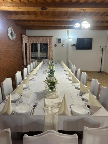 a long table with white tables and chairs in a room at Penzión Nezábudka in Stropkov