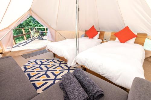 a tent with two beds and a couch in a room at 舞子グランピング in Minami Uonuma