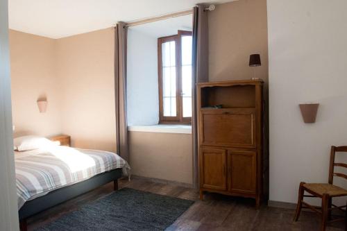 a bedroom with a bed and a window and a dresser at La vallée de Gaïa in Saint-Hilaire-de-Lavit