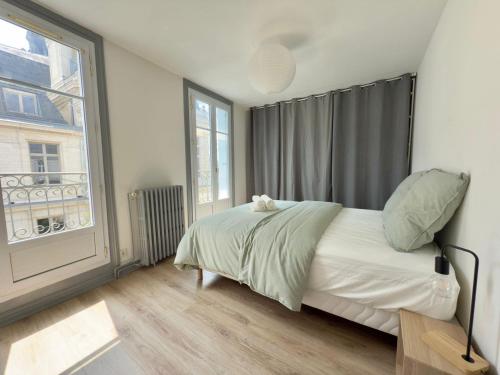 une chambre avec un lit et une grande fenêtre dans l'établissement Pause sur la place, à Poitiers