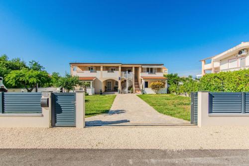 a house with a gate in front of it at Apartments with parking spaces Zukve, Zadar - 24559 in Nin