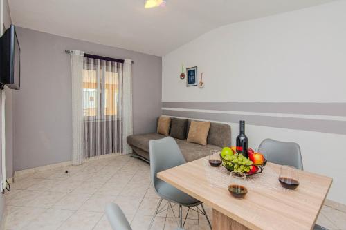 a living room with a table and a couch at Apartments with parking spaces Zukve, Zadar - 24559 in Nin