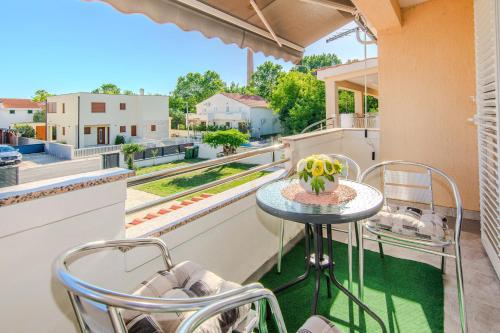 a balcony with a table and chairs and a view at Apartments with parking spaces Zukve, Zadar - 24559 in Nin