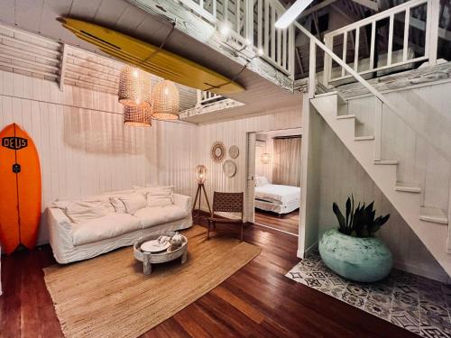 a living room with a white couch and a staircase at Beach Lifestyle Bungalow in Motu Tiahura