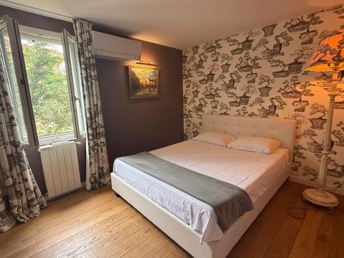 une chambre avec un lit et une grande fenêtre dans l'établissement Maison calme à 2 pas du port du Brusc, à Six-Fours-les-Plages