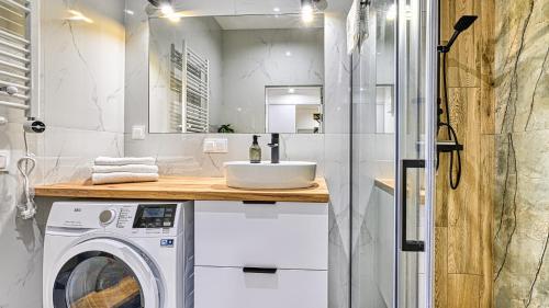 un bagno con lavandino e lavatrice di Apartament SPA 2 USTRONNIE Residence - 5D Apartments a Ustronie Morskie