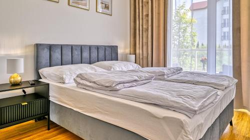 un letto grande in una camera da letto con finestra di Apartament SPA 2 USTRONNIE Residence - 5D Apartments a Ustronie Morskie