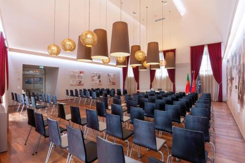 a large room with chairs and tables and chandeliers at Vila Galé Casas d'Elvas - Historic Hotel in Elvas