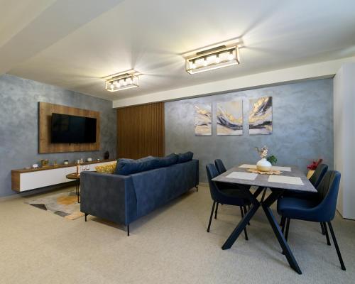 a living room with a blue couch and a table at Nadesa - Mountain View Villas in Zărneşti