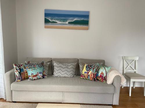 a gray couch with pillows in a living room at Villa Dona Rosa - Viana do Castelo in Viana do Castelo