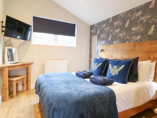 a bedroom with a large bed with a blue blanket at Birch in Swadlincote