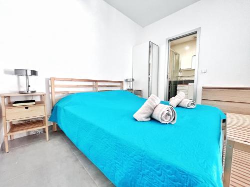 une chambre avec un lit bleu avec des serviettes dessus dans l'établissement Les Orangers de Menton 1P and terraces, à Menton