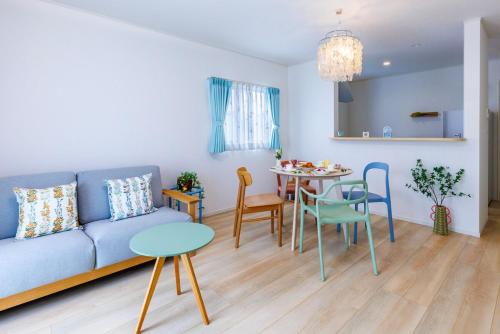 a living room with a blue couch and a table at 那覇空港から15分DMM水族館とイーアス豊崎近く最大10名oKの南部リゾート宿OKS inn in Itoman