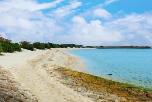 a beach with the ocean and a blue sky at 那覇空港から15分DMM水族館とイーアス豊崎近く最大10名oKの南部リゾート宿OKS inn in Itoman