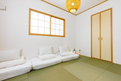a living room with a white couch and a window at 那覇空港から15分DMM水族館とイーアス豊崎近く最大10名oKの南部リゾート宿OKS inn in Itoman