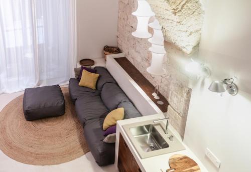 a living room with a couch and a stone wall at Loft Serisso in Trapani