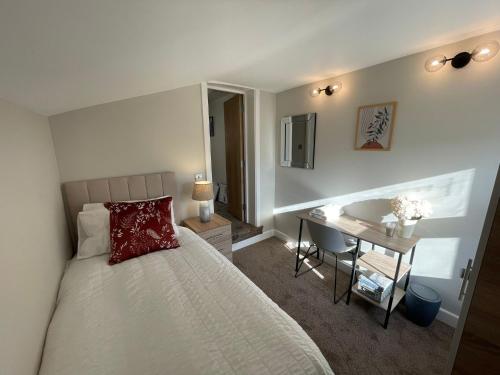 a bedroom with a bed and a desk and a sink at Luxury 4-Bedroom Haven Garden Parking in South Norwood