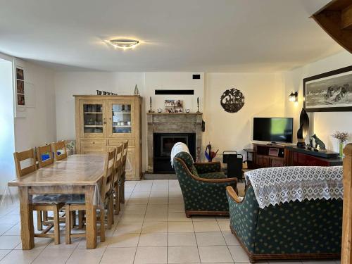 un salon avec une table et des chaises et une cheminée dans l'établissement 309 - Charmante maison familiale au cœur du village de Port-à-La-Duc, à Fréhel