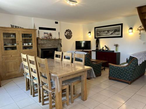 une salle à manger avec une table et des chaises en bois dans l'établissement 309 - Charmante maison familiale au cœur du village de Port-à-La-Duc, à Fréhel